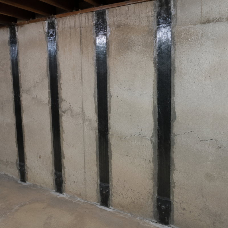 Carbon fiber straps professionally installed on a bowing basement foundation wall.